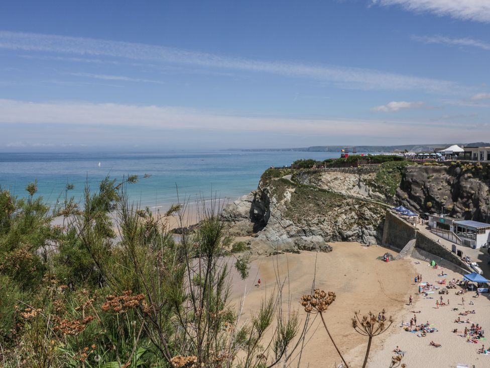 A beach with people and cliffs at Shoreline Apartment No.8 in Newquay