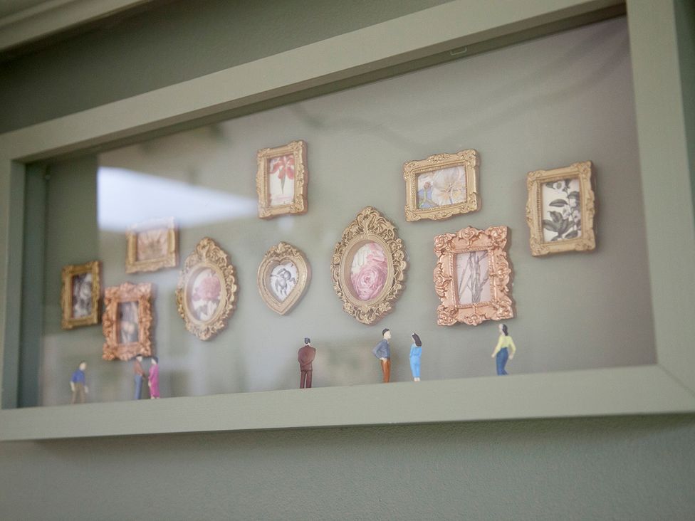 A display of picture frames with miniature figures at Snug Cottage in Honley