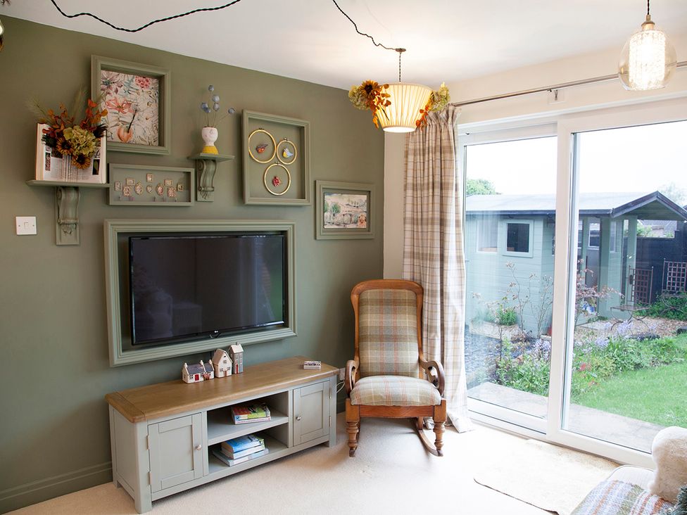 A living room with a television and armchair at Snug Cottage in Honley