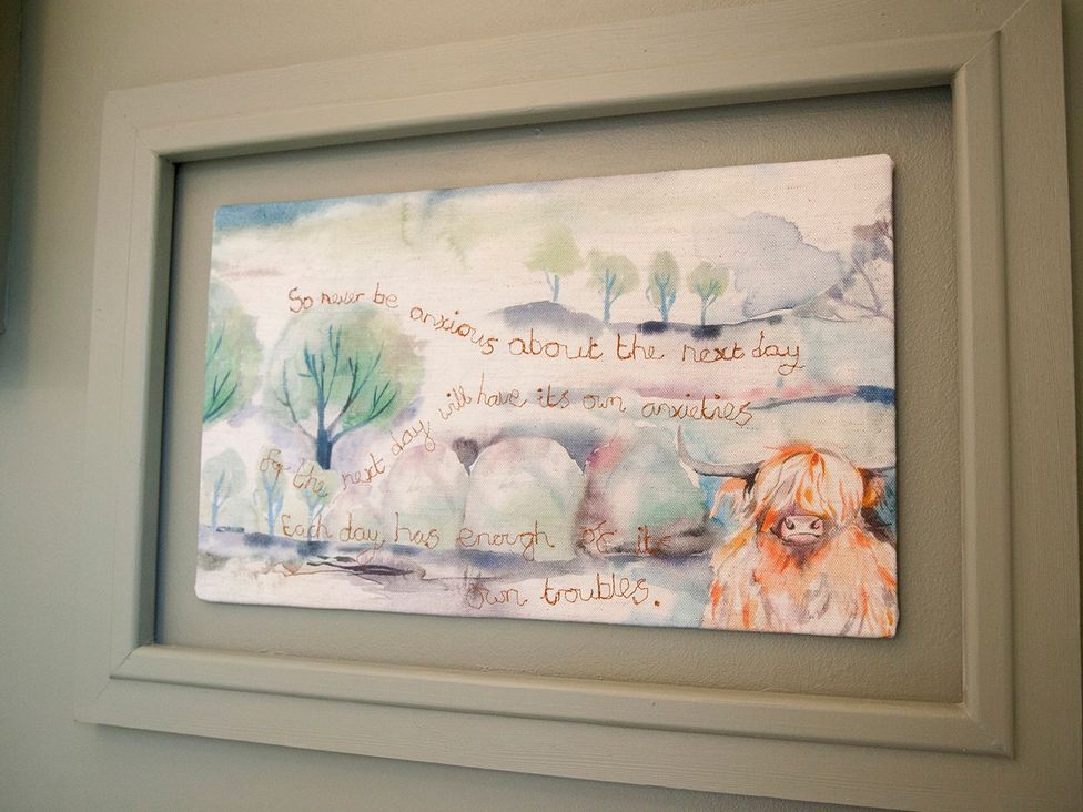 A framed artwork with a cow and text at Snug Cottage in Honley