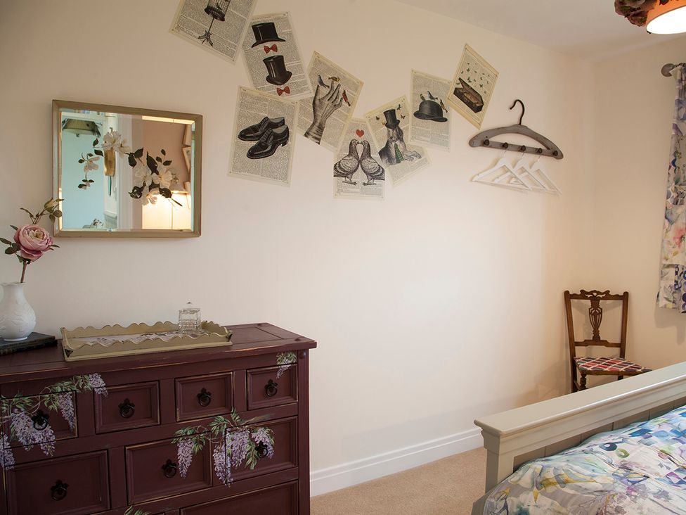 A bedroom with a dressing table and mirror at Snug Cottage in Honley