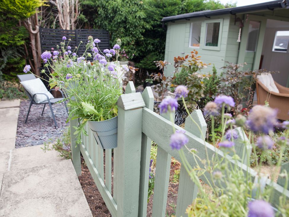 A garden with flowers on a fence at Snug Corner in Honley