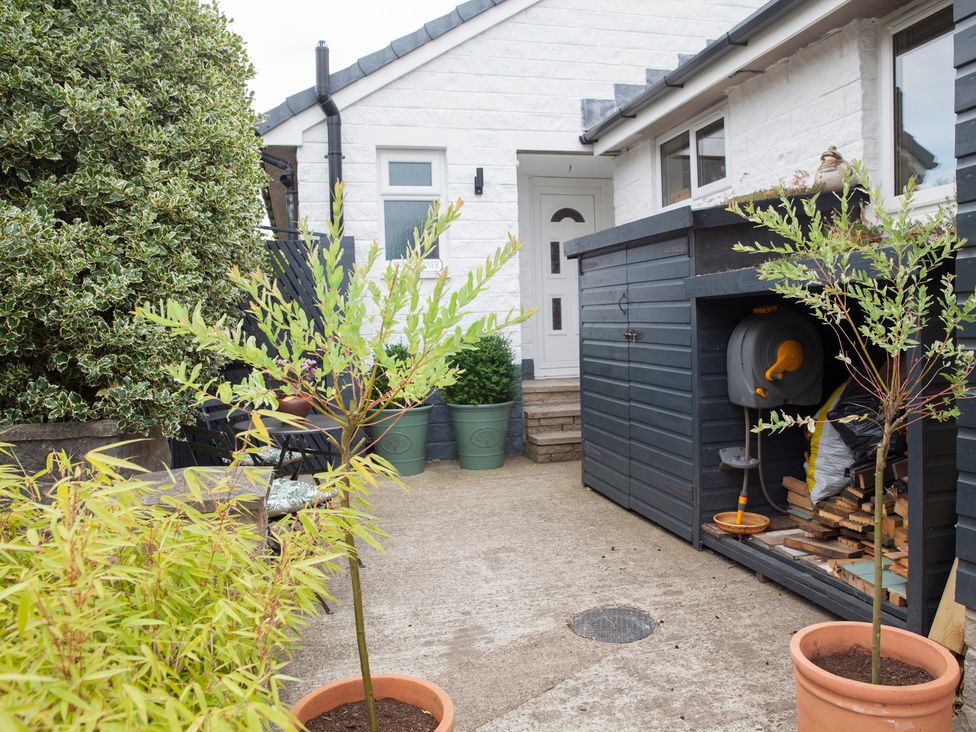 A garden with pots and a shed at Snug Corner in Honley