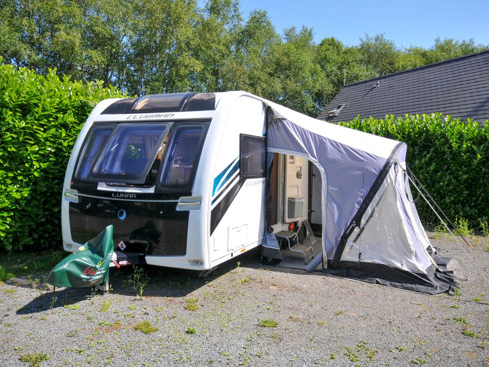 A caravan with an awning and chairs at Caravan in Dolton