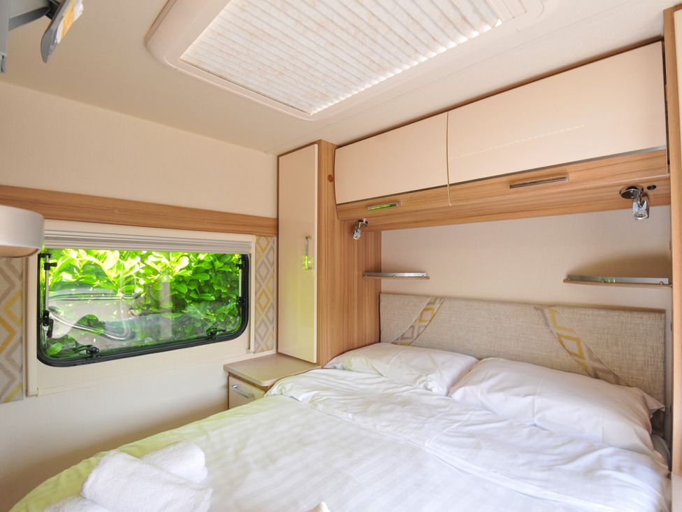 A bedroom with a bed and window at Caravan in Dolton
