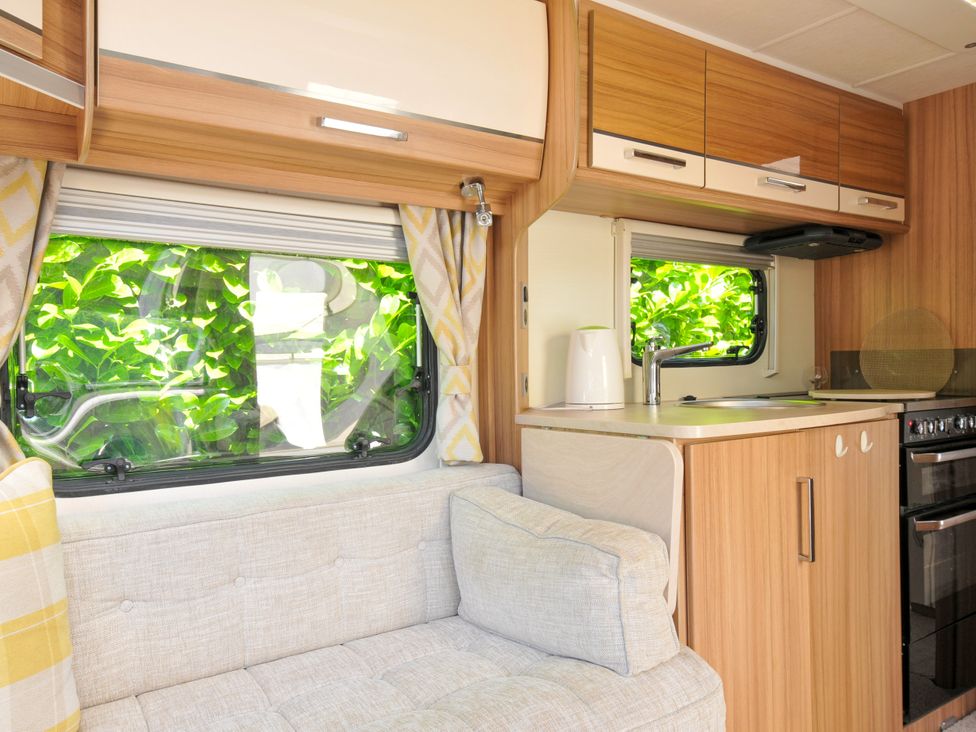 A kitchen with a sofa and window at Caravan in Dolton