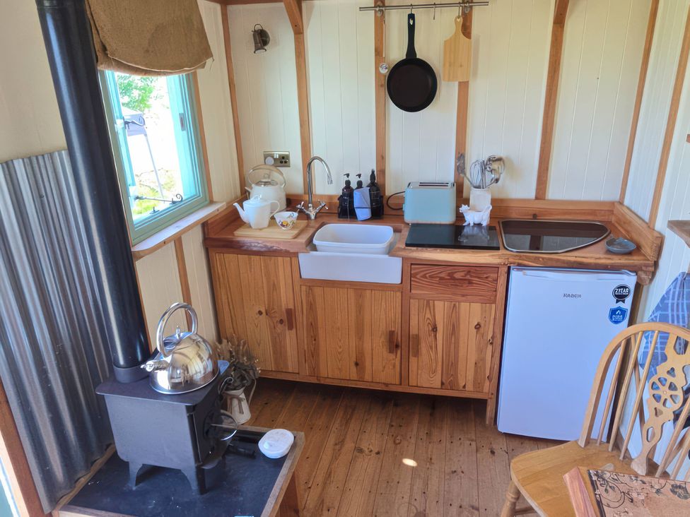A kitchen with a wooden countertop and sink at Cwt Bugail in Pwllheli