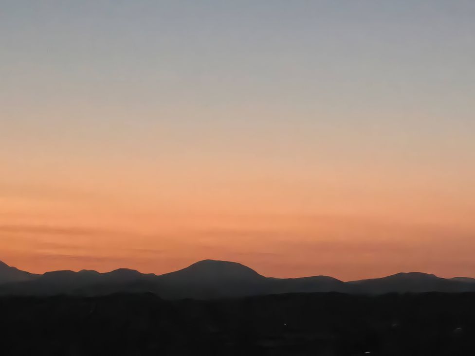 A view of mountains and sky during sunset at Cwt Bugail in Pwllheli
