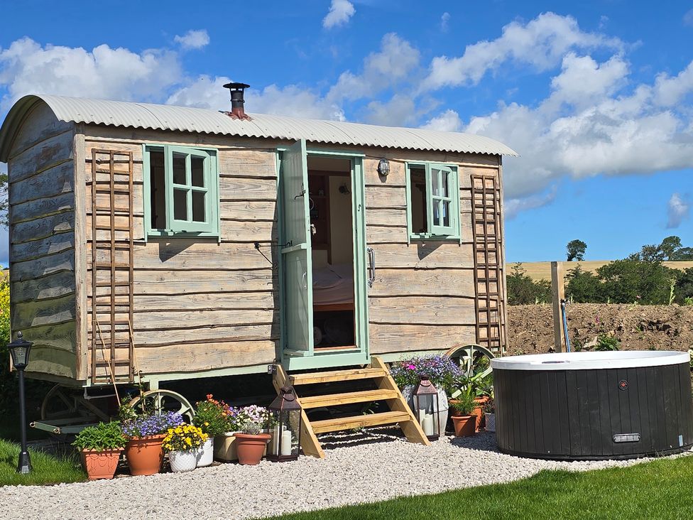 A hut with steps and a hot tub at Cwt Bugail Pwllheli