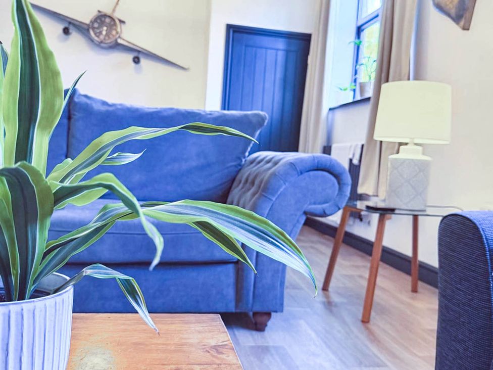 A living room with a blue sofa and houseplant at Stunning Retreat in the Heart of Matlock Bath