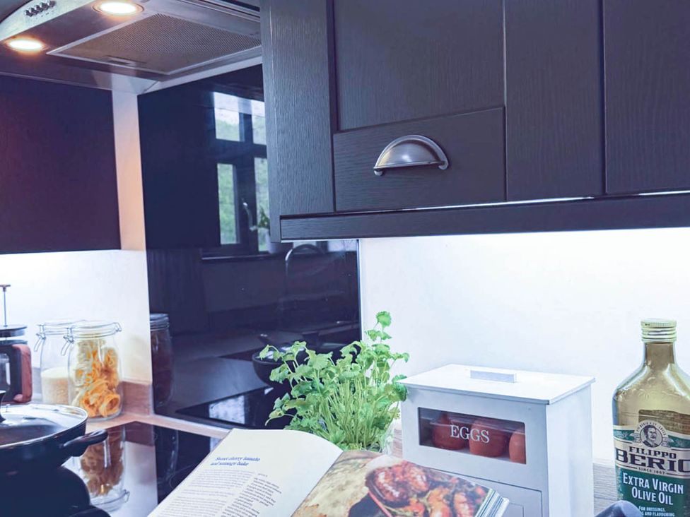 A kitchen with a cookbook and olive oil at Stunning Retreat in the Heart of Matlock Bath