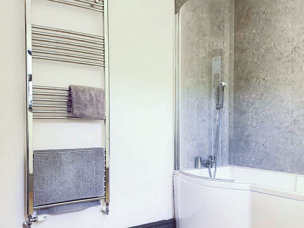 A bathroom with a towel rail and a shower over a bathtub at Stunning Retreat in the Heart of Matlock Bath