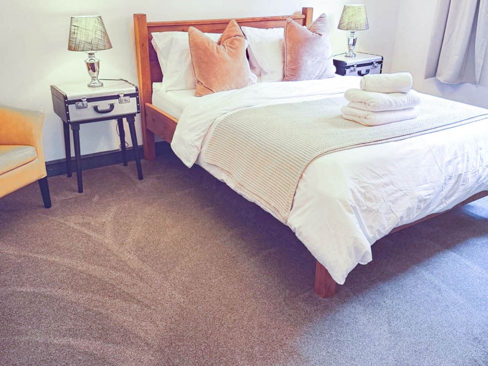 A bedroom with a bed and lamp at Stunning Retreat in the Heart of Matlock Bath