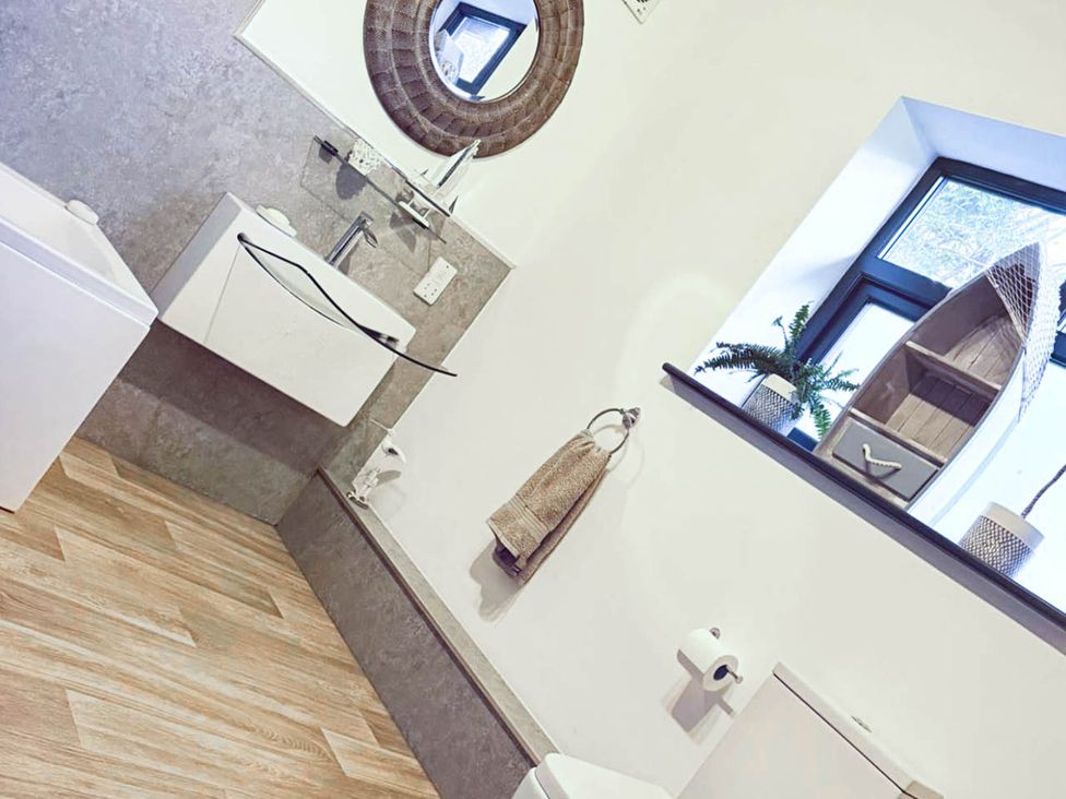 A bathroom with a sink, toilet, and mirror at Stunning Retreat in the Heart of Matlock Bath near Matlock