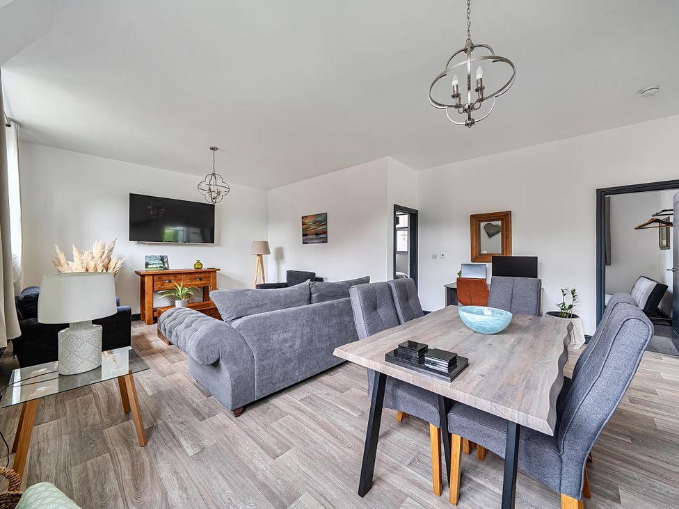 A living room with a sofa, dining table, and TV at Stunning Retreat in the Heart of Matlock Bath