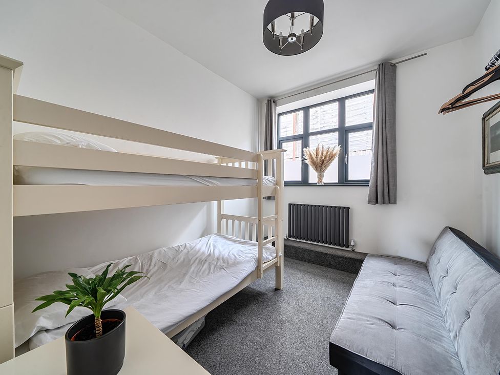 A bedroom with a bunk bed and sofa at Stunning Retreat in the Heart of Matlock Bath Matlock Bath near Matlock