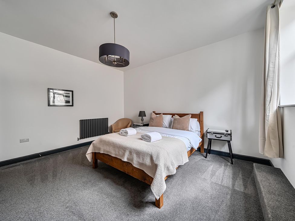 A bedroom with a bed and bedside table at Stunning Retreat in the Heart of Matlock Bath, Matlock Bath near Matlock