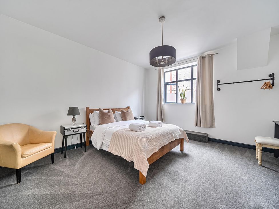 A bedroom with a bed, chair, and window at Stunning Retreat in the Heart of Matlock Bath Matlock Bath near Matlock