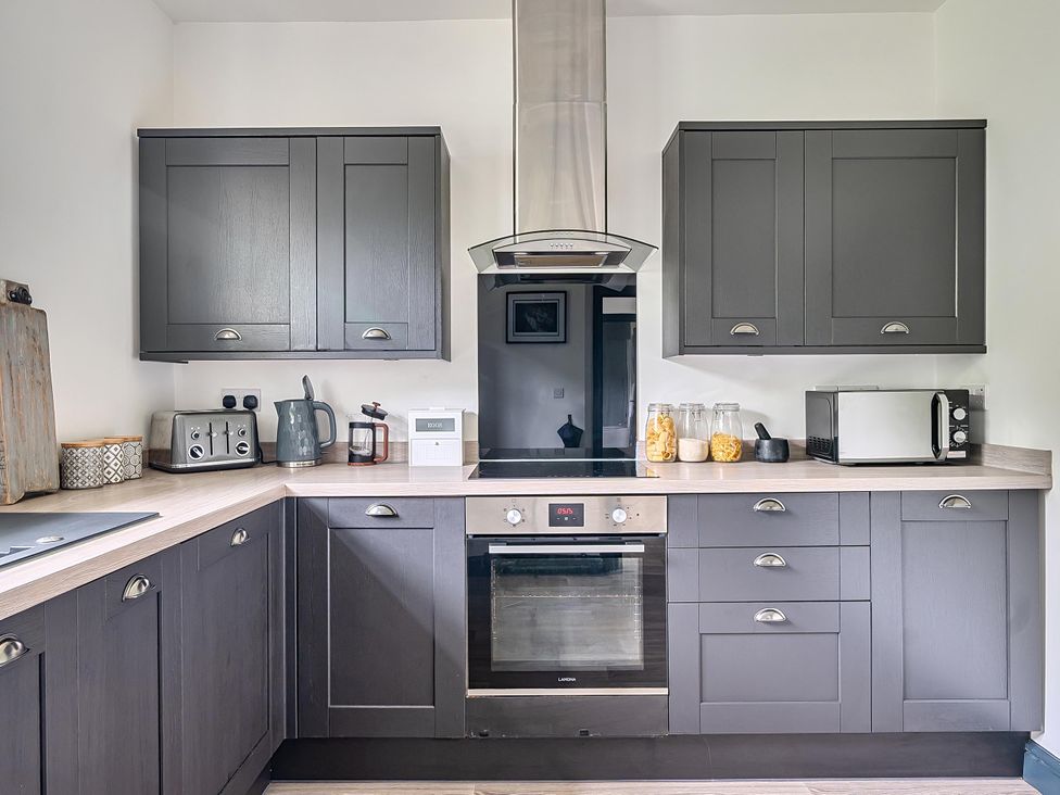 A kitchen with appliances and cabinets at Stunning Retreat in the Heart of Matlock Bath Matlock Bath near Matlock