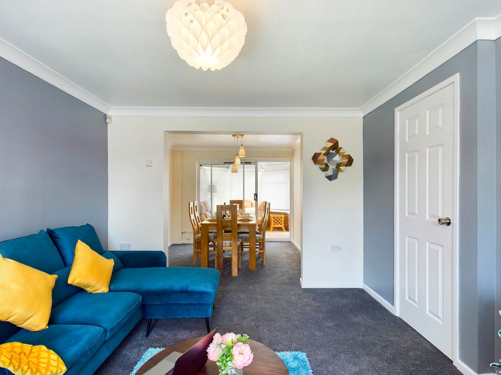A living room with a sofa and dining area at Tranquil Telford Retreat - 3 Bedroom House, Telford