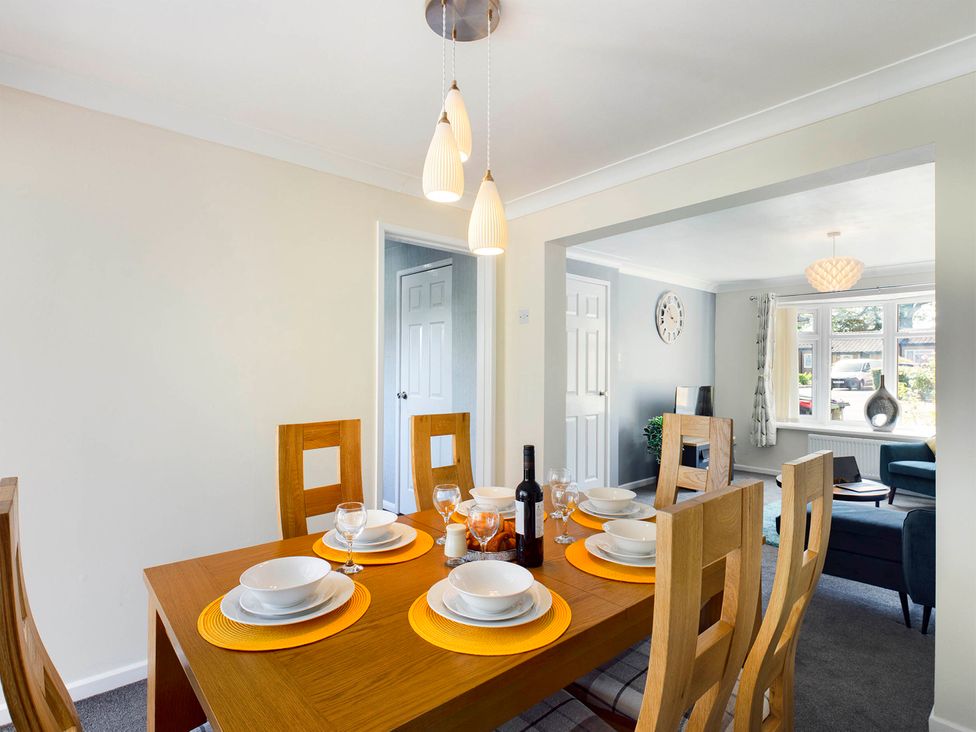 A dining room with a table set for dinner at Tranquil Telford Retreat - 3 Bedroom House in Telford
