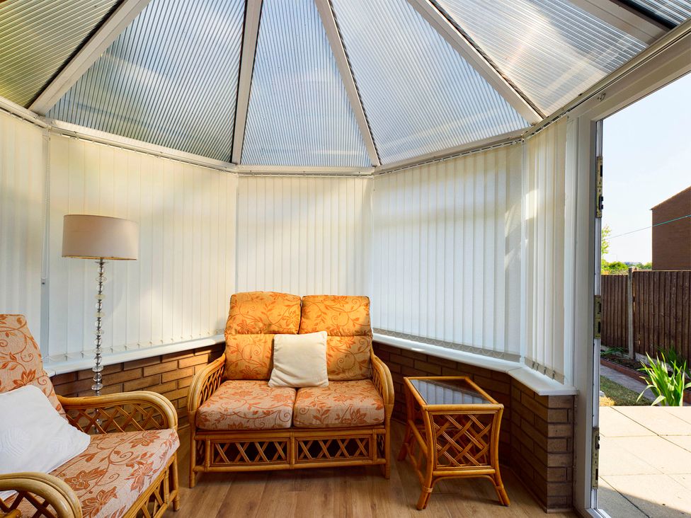A conservatory with a sofa and lamp at Tranquil Telford Retreat - 3 Bedroom House in Telford