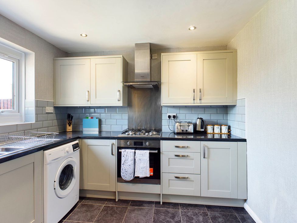 A kitchen with cabinets and appliances at Tranquil Telford Retreat - 3 Bedroom House Telford