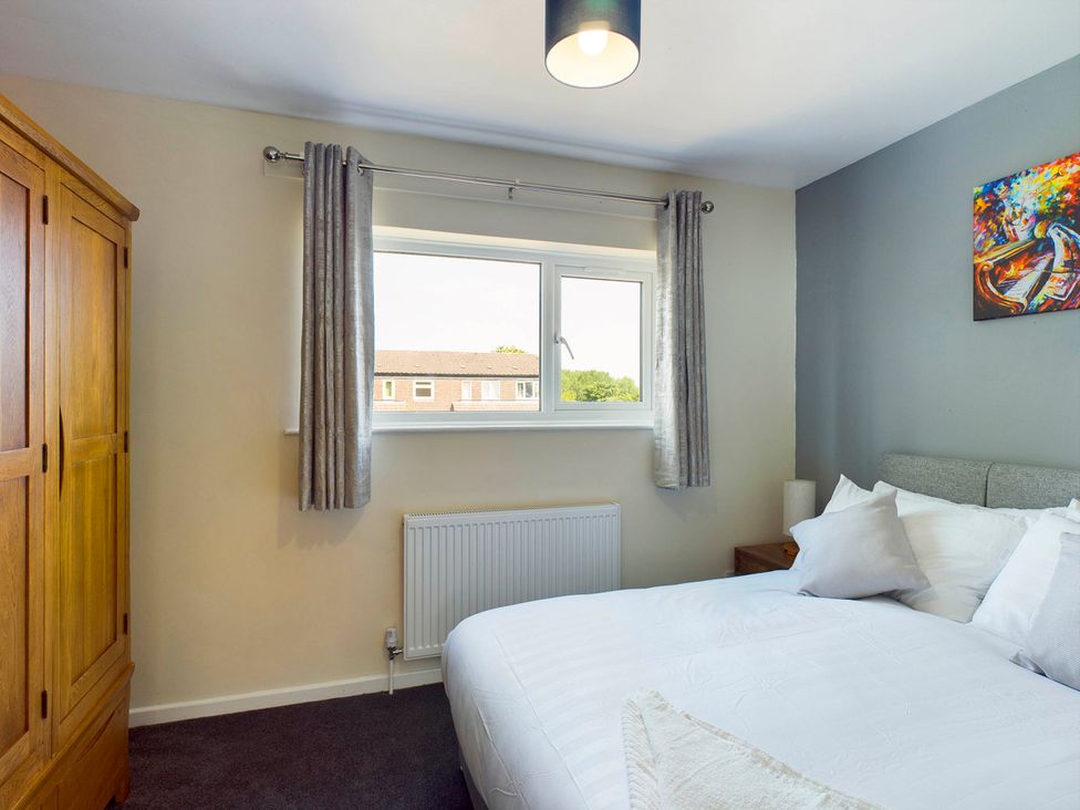 A bedroom with a bed and wardrobe at Tranquil Telford Retreat - 3 Bedroom House in Telford