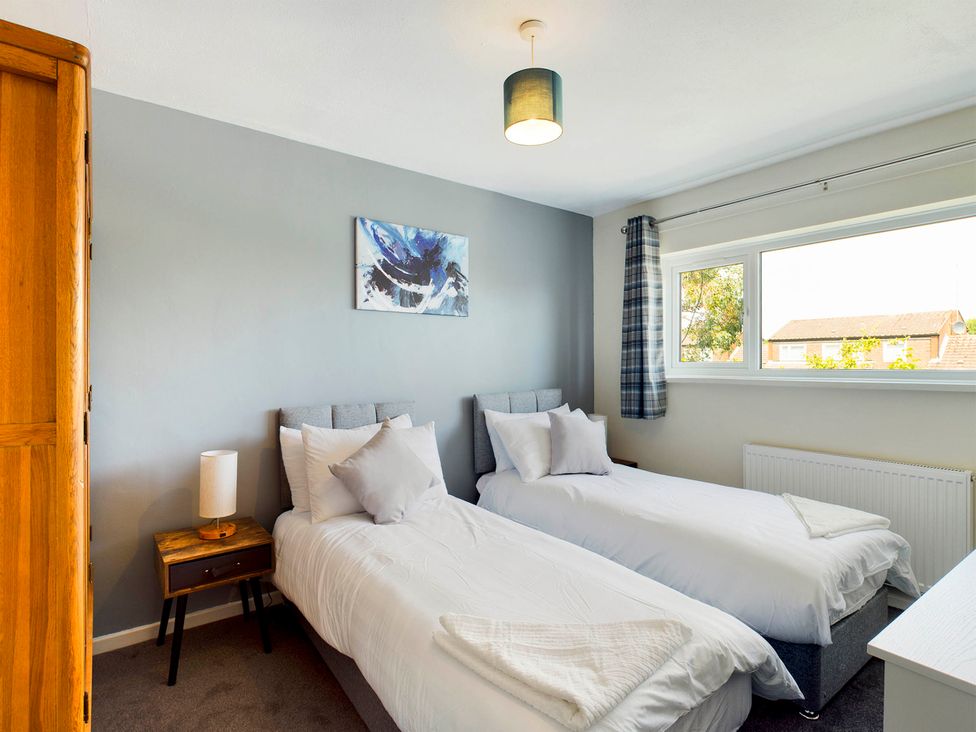 A bedroom with two single beds and a bedside table at Tranquil Telford Retreat - 3 Bedroom House Telford