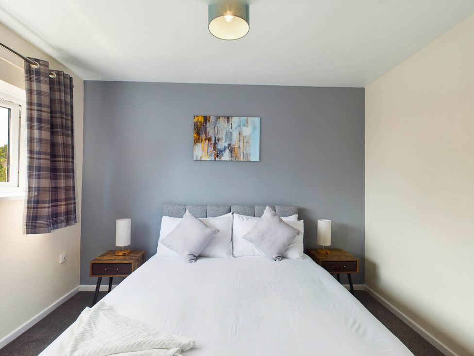 A bedroom with a bed and nightstand at Tranquil Telford Retreat - 3 Bedroom House in Telford