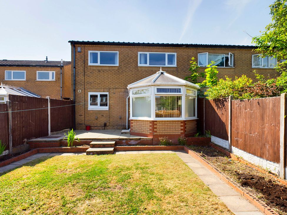 A garden with a conservatory and paved area at Tranquil Telford Retreat - 3 Bedroom House in Telford