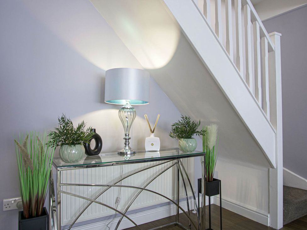 A console table with a lamp and decorative items at Cozy Riverside Retreat in Snodland