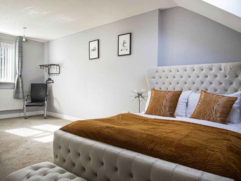 A bedroom with a bed and chair at Cozy Riverside Retreat in Snodland