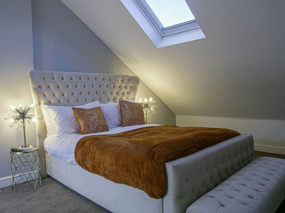 A bedroom with a bed and bedside tables at Cozy Riverside Retreat in Snodland