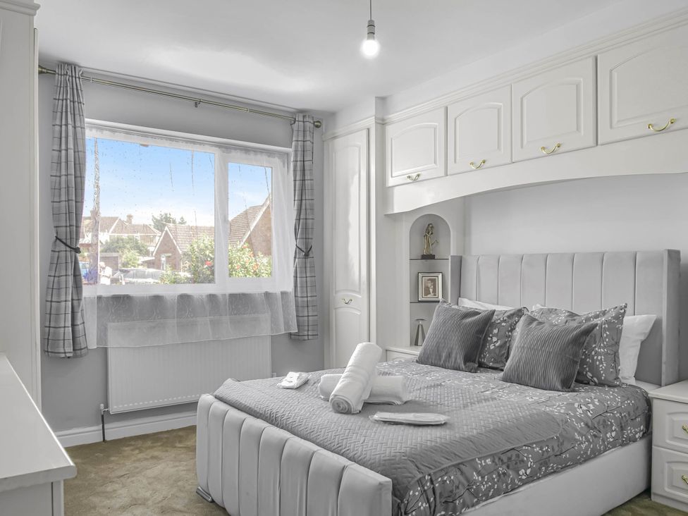 A bedroom with a bed and shelves at Cozy Riverside Retreat in Snodland