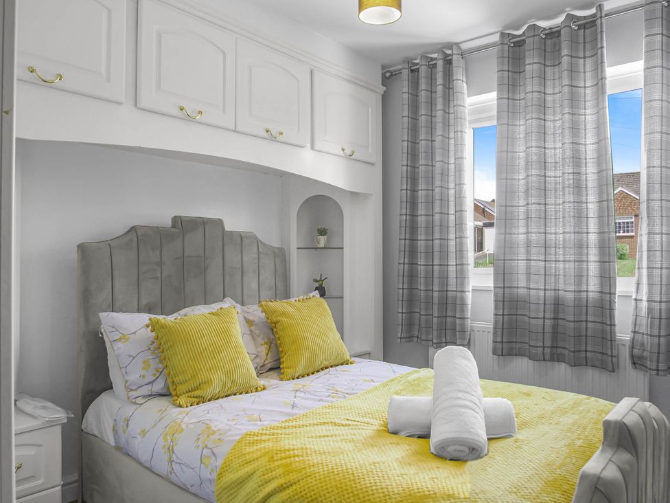 A bedroom with a bed and shelves at Cozy Riverside Retreat in Snodland