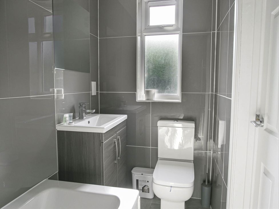 A bathroom with a sink, toilet, and bath at Cozy Riverside Retreat in Snodland