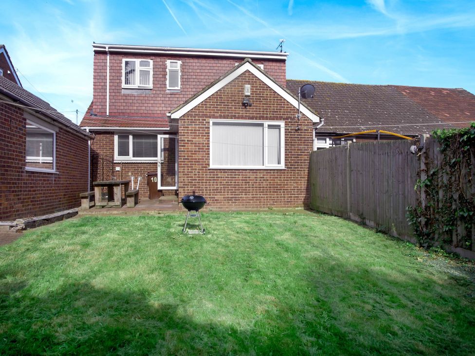A garden with a house and a barbecue grill at Cozy Riverside Retreat in Snodland