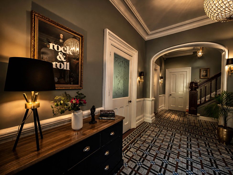 A hallway with a console table and a lamp at Chowdene Lodge Estate