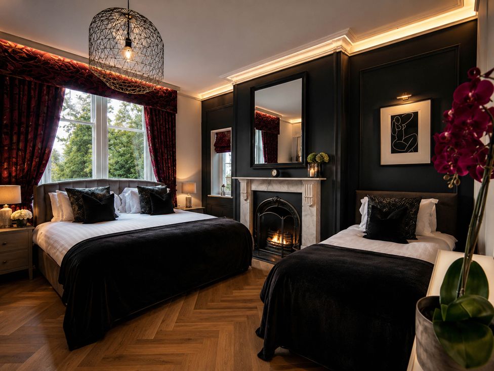 A bedroom with two beds and a fireplace at Chowdene Lodge Estate