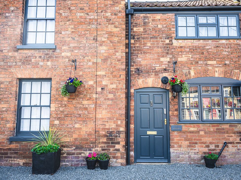 An entrance with a door and windows on a brick wall at a property