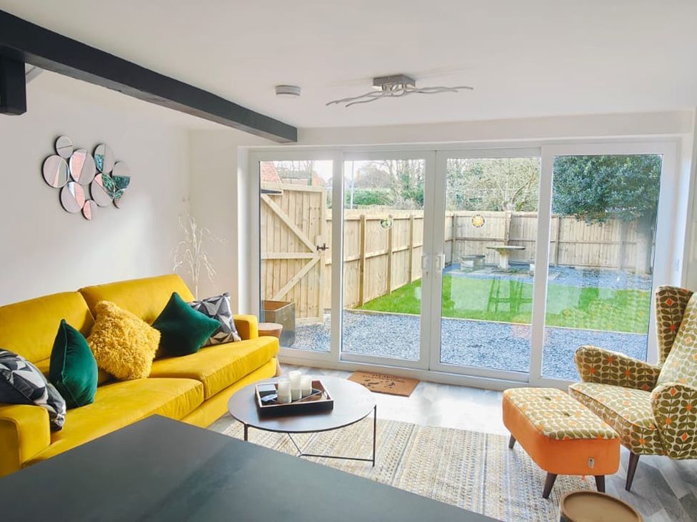 A living room with a sliding door and outdoor view at The Old Barn in Manchester