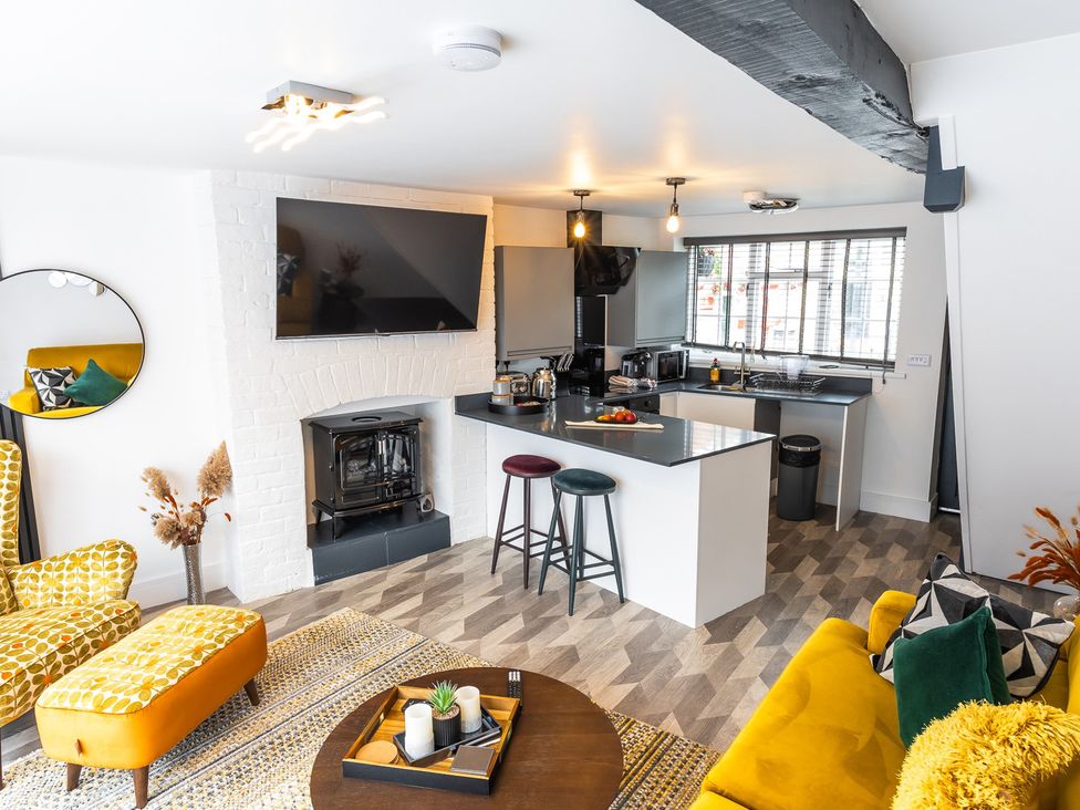 A living room with a kitchen area and television at the property in location