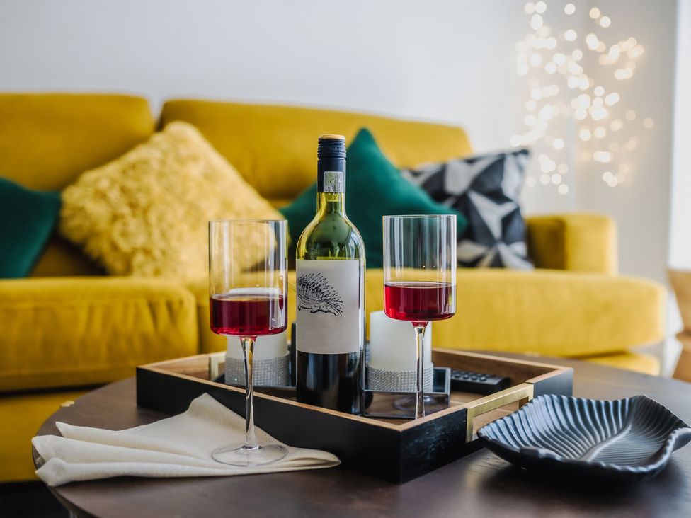 A coffee table with wine glasses and a bottle in a living room