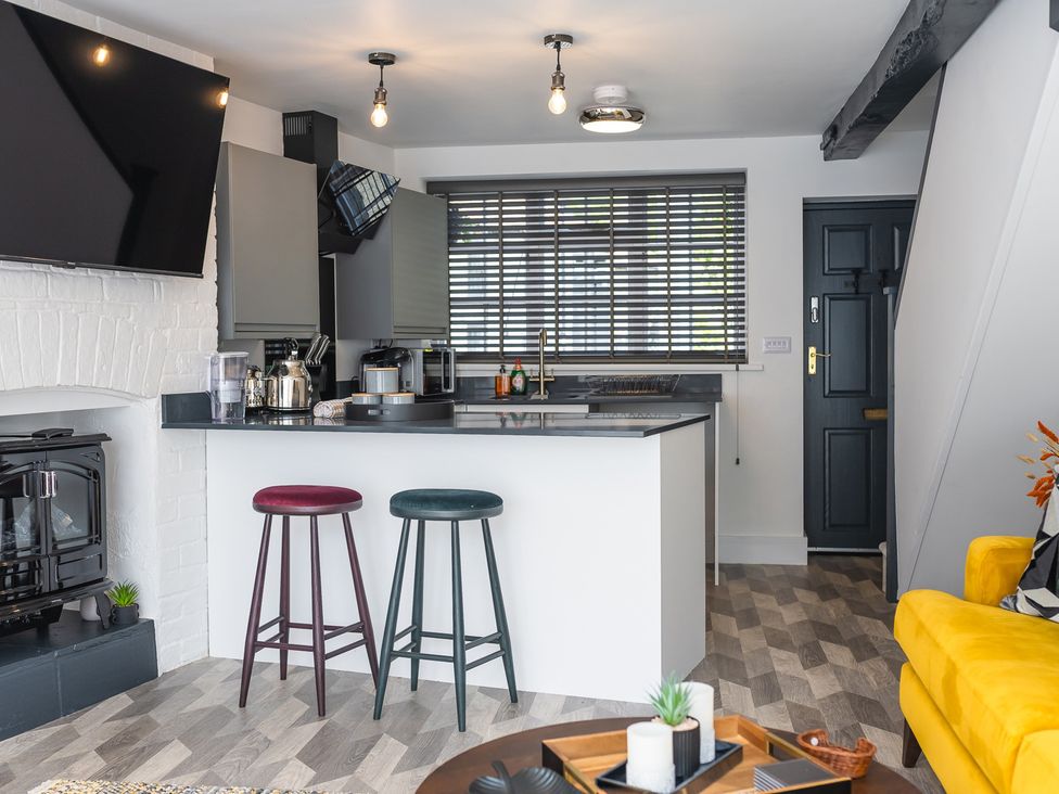A kitchen with bar stools and modern appliances at an unspecified location