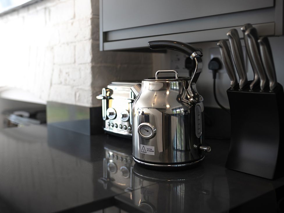 A kitchen with a kettle and toaster on the countertop