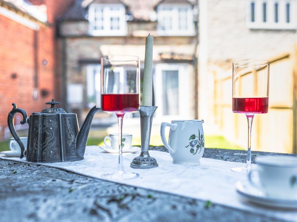 A table setting with teapot and glasses in a garden at 