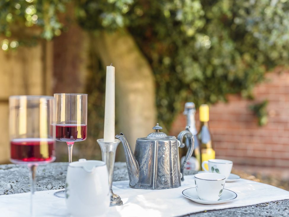 A table setting with drinks and a teapot outdoors
