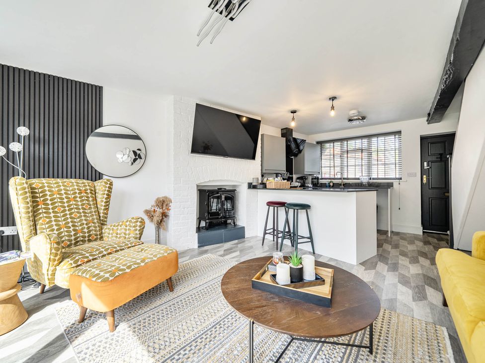 A living room with a fireplace and kitchen island at Captivating 2 Bed House in Nettleham