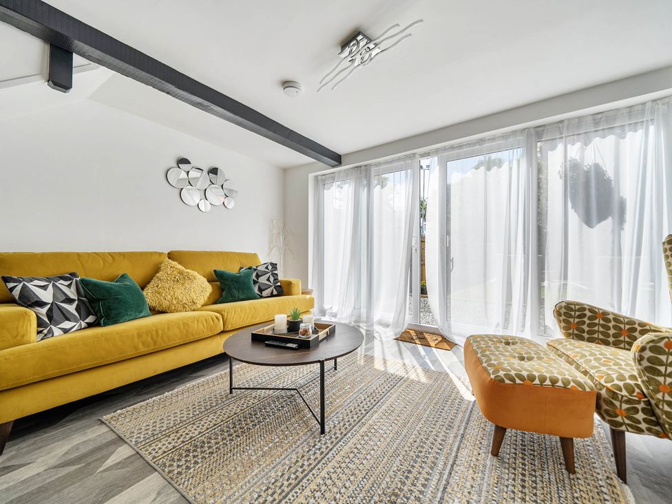 A living room with a yellow sofa and a coffee table at Captivating 2 Bed House in Nettleham